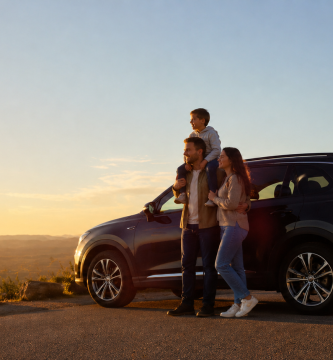 Family standing beside an SUV on a scenic road at sunset