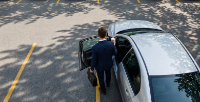 Driver getting into a car in a parking lot for a guide about car insurance deductibles
