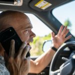 High-risk driver calling insurance company from his car