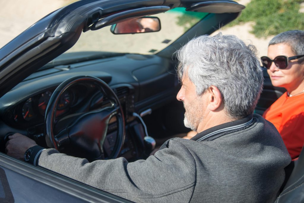 Senior driver sitting in a convertible car