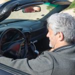Senior driver sitting in a convertible car