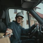 Delivery driver loading packages into a delivery van