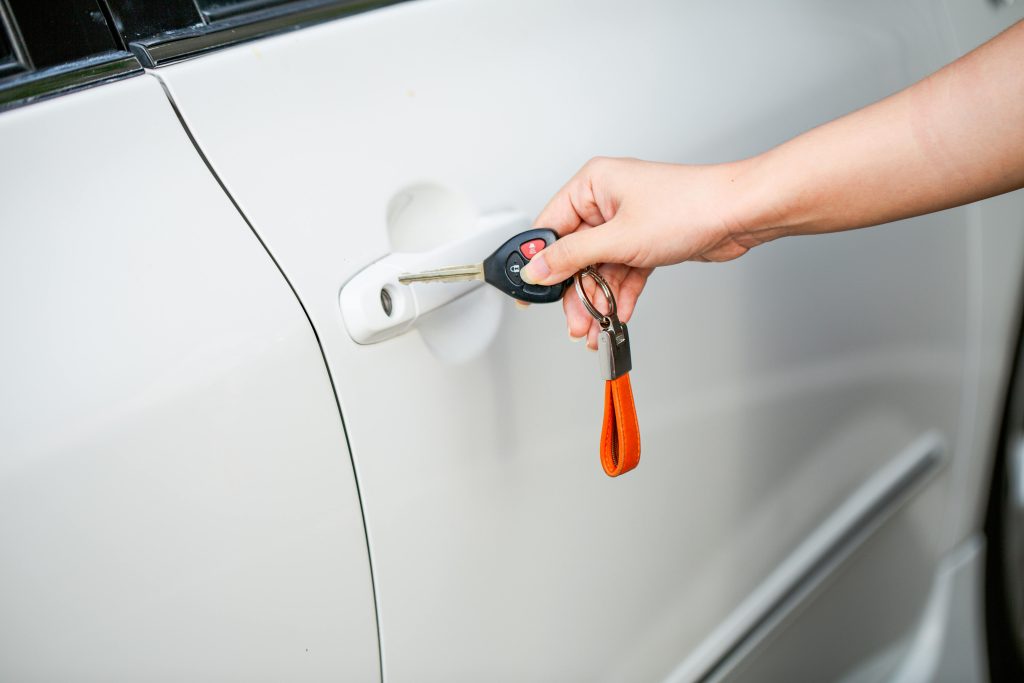 Hand holding car keys near a vehicle door