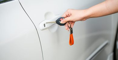Hand holding car keys near a vehicle door