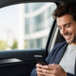 Driver checking a usage-based car insurance app inside a parked car