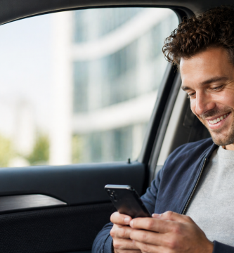 Driver checking a usage-based car insurance app inside a parked car