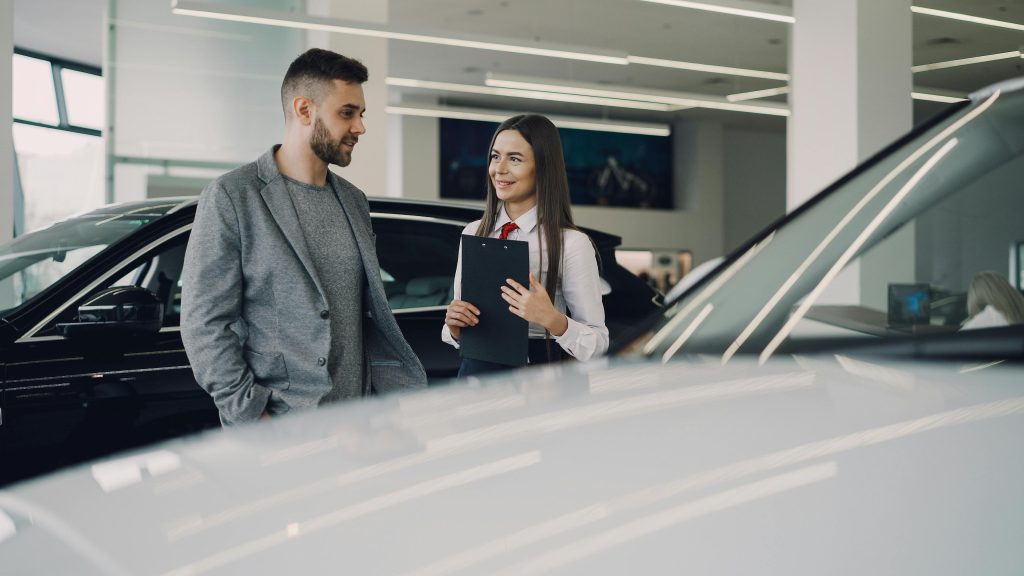 Driver discussing temporary car insurance options at a car dealership in Texas