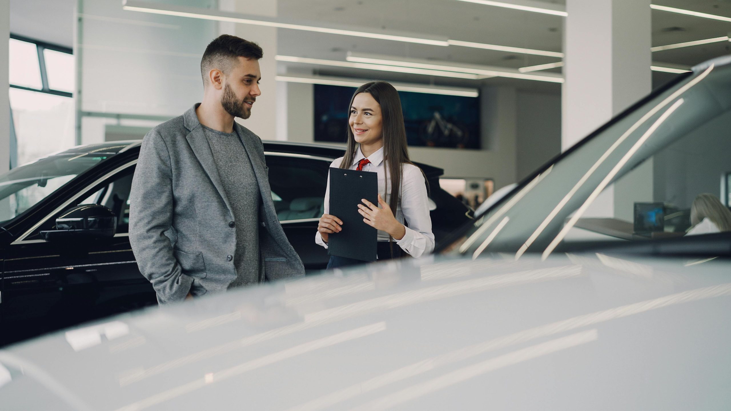 Driver discussing temporary car insurance options at a car dealership in Texas