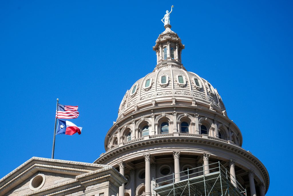Texas State Capitol building with American and Texas flags