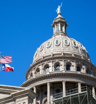 Texas State Capitol building with American and Texas flags
