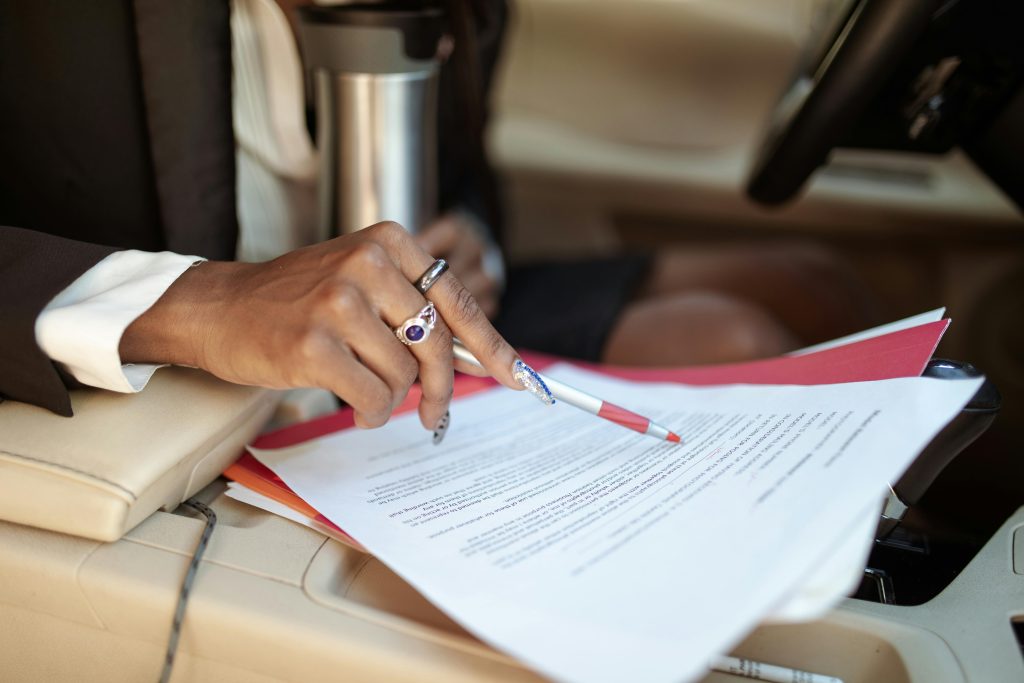 Person reviewing car insurance documents inside a car