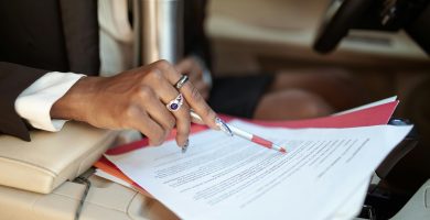 Person reviewing car insurance documents inside a car